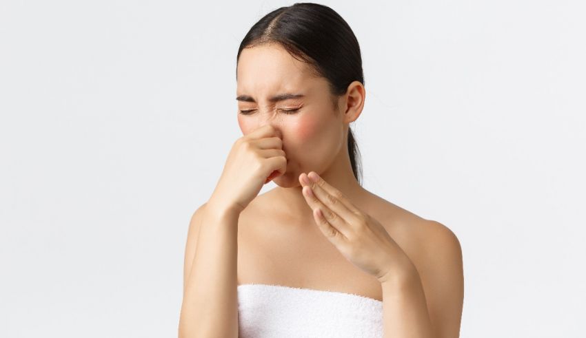 A woman is rubbing her nose with a towel.