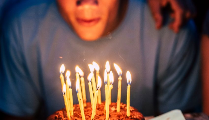 A man blowing out candles on a birthday cake.