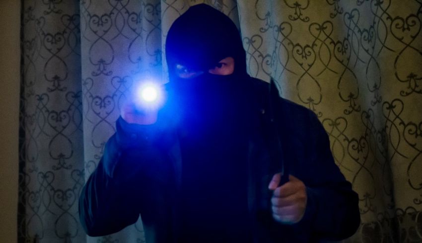 A man in a hoodie holding a flashlight.