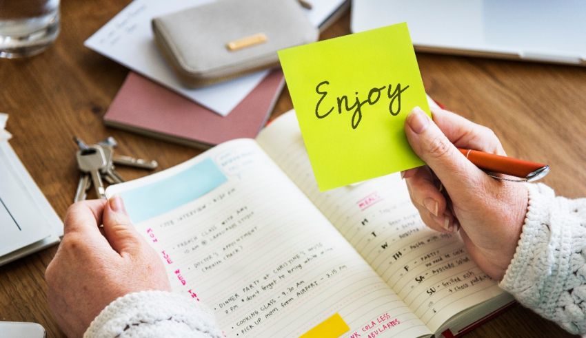 A person holding a sticky note with the word enjoy on it.