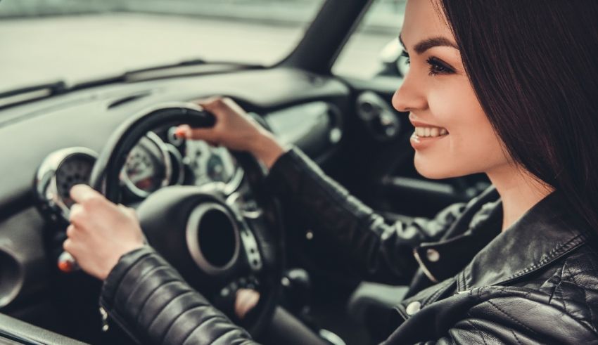 A woman is driving a car with a smile on her face.