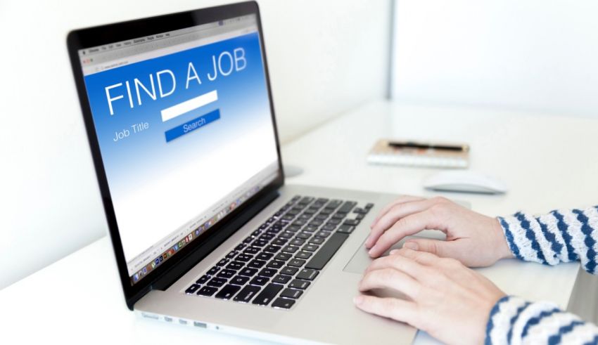 A person typing on a laptop with the word find a job on it.