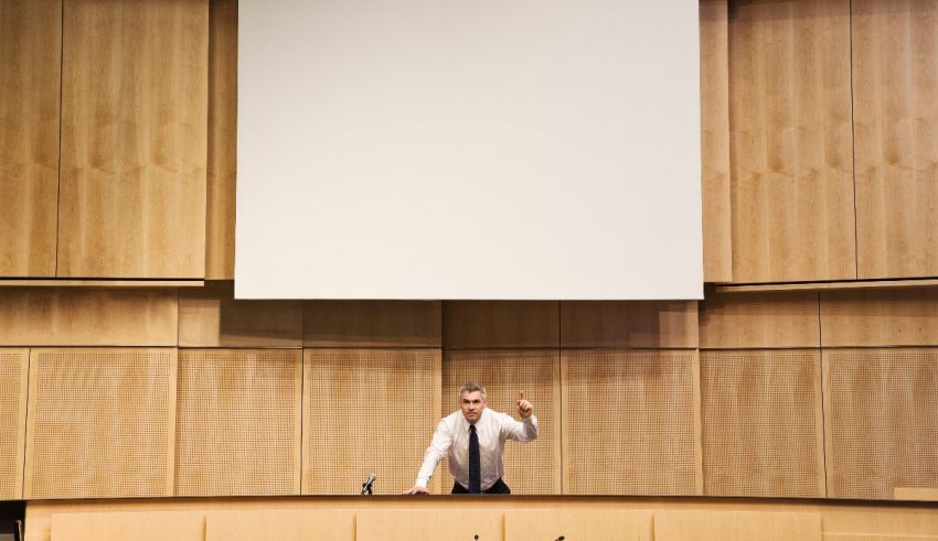 A man giving a speech in a conference room.