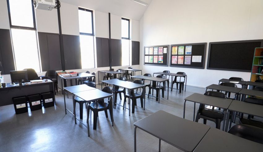 An empty classroom with desks and chairs.