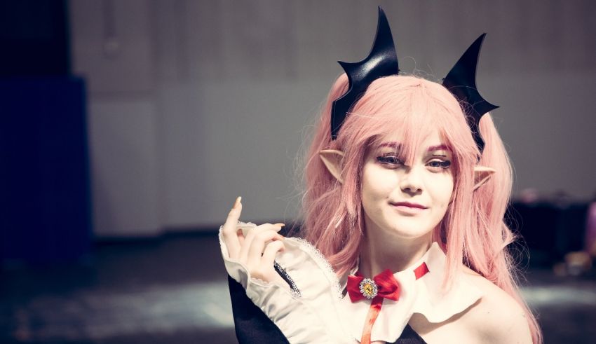 A girl dressed as a demon with pink hair and horns.