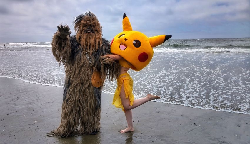 Two people dressed as chewbacca and pikachu on the beach.
