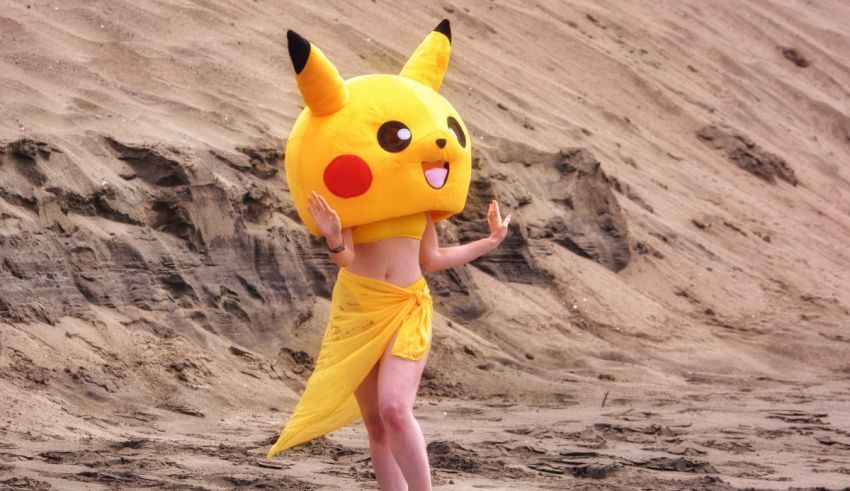 A woman in a pikachu costume standing on the beach.