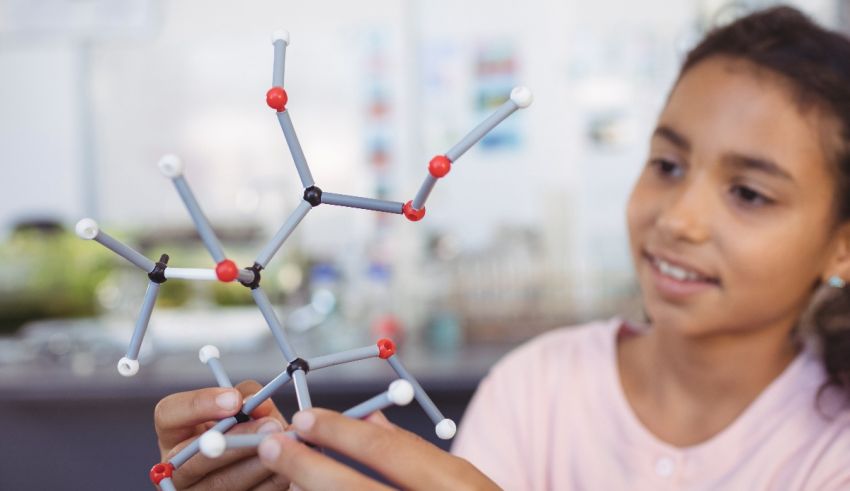 A girl is holding a model of a molecule in her hands.