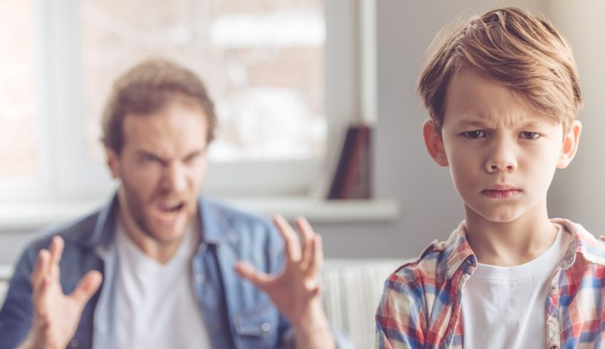 A young boy is screaming at his father in front of a living room.