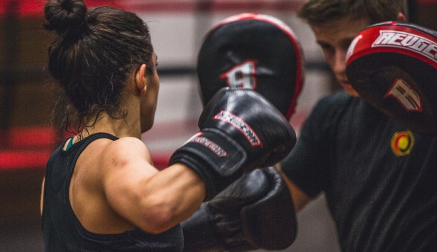 A woman and a man boxing in a gym.