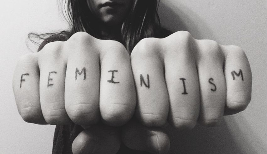 A woman's hands with the word feminism written on them.