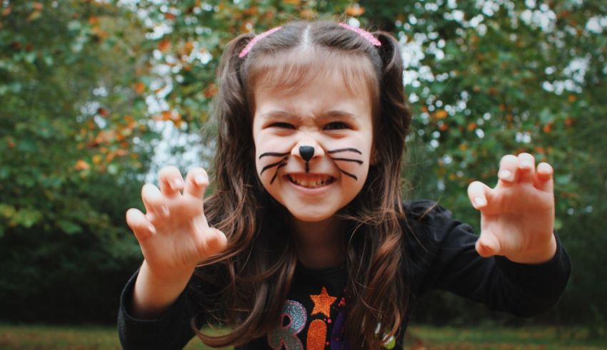 A little girl with a cat face is posing for a picture.
