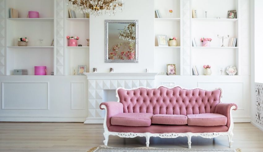 A pink couch sits in front of a white wall.