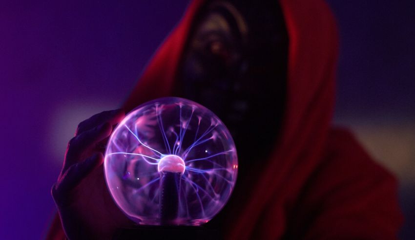 A person in a red hoodie holding a glowing ball of electricity.