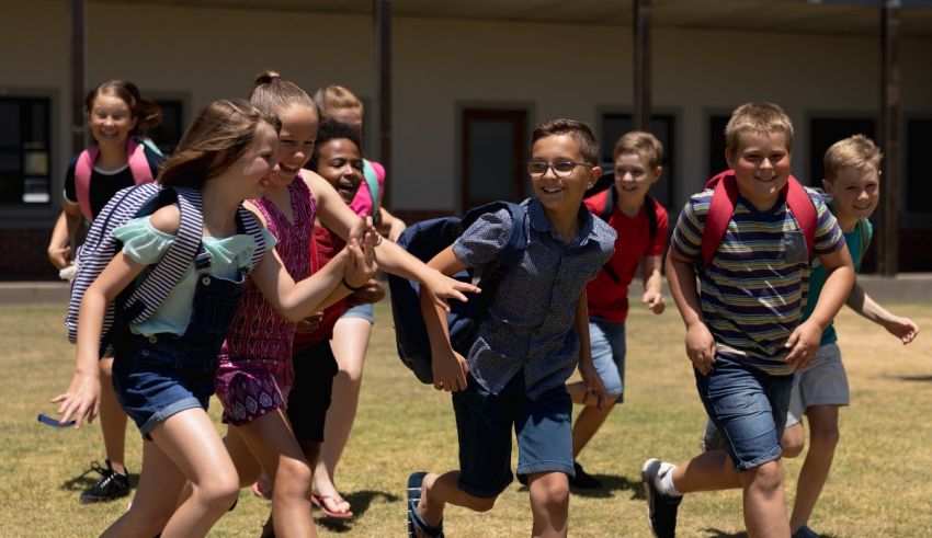 A group of children running with backpacks.