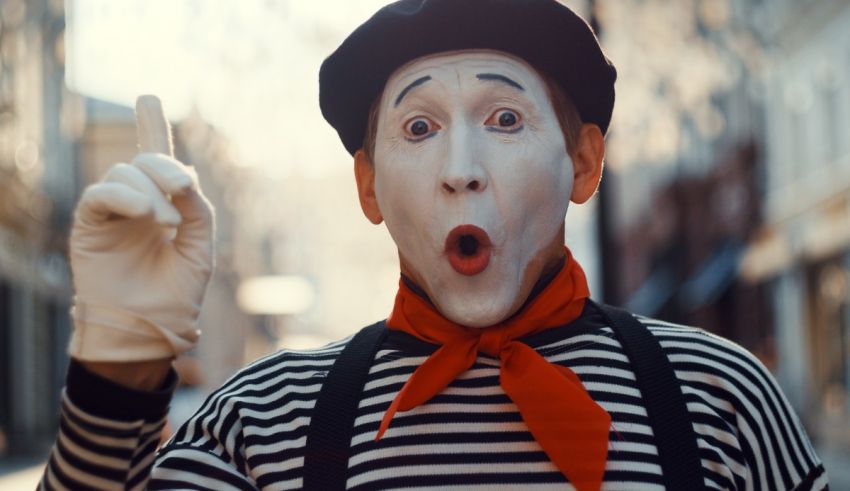 A man dressed as a mime is making a gesture.