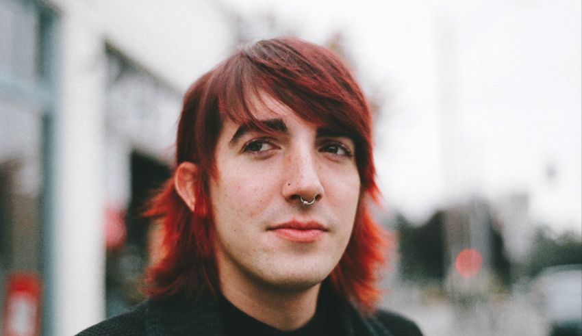 A young man with red hair and piercings.