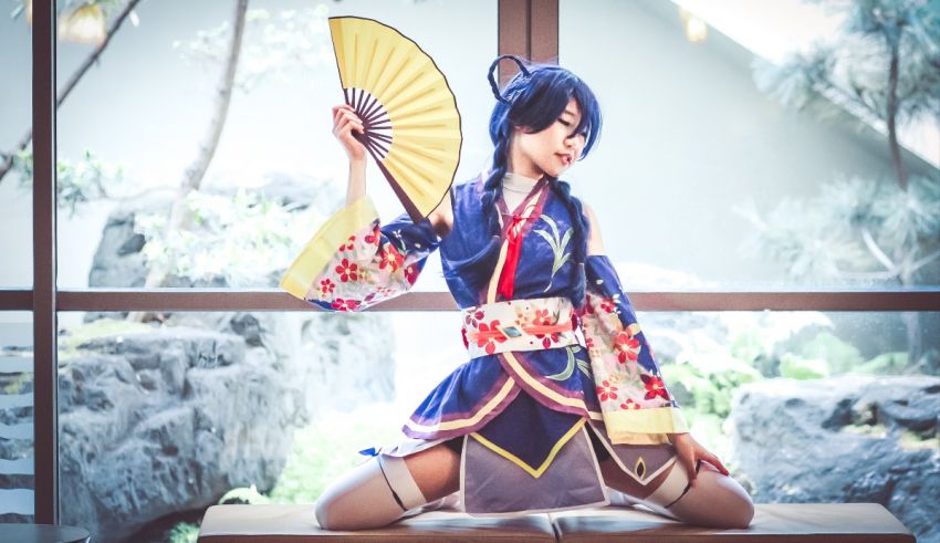 A girl in a kimono is posing with a fan.