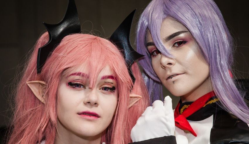 Two cosplayers with pink hair and horns posing for a photo.
