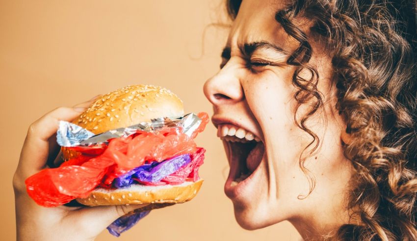 A woman is eating a large hamburger.
