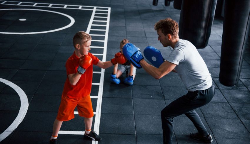 A man and a boy boxing in a gym.