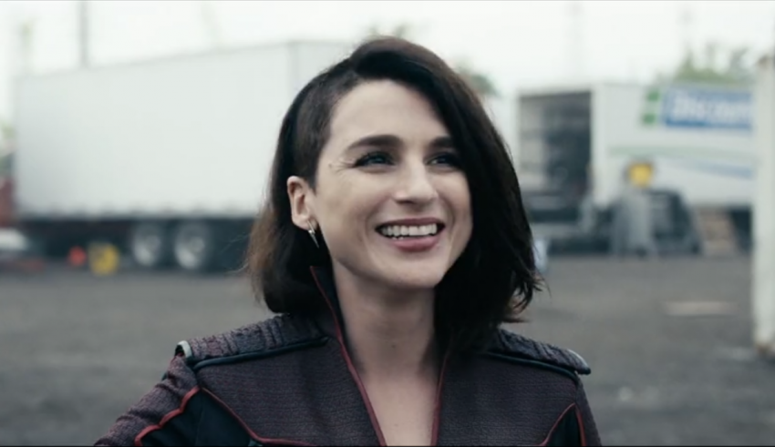 A woman is smiling in front of a truck.