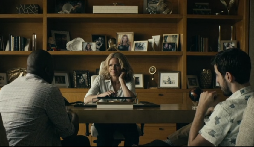 A group of people sitting around a table in a living room.