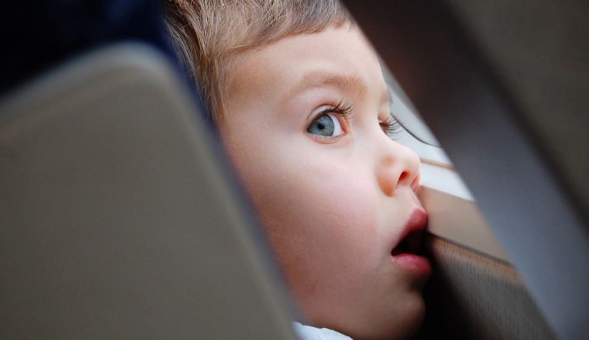 A child looking out the window of a plane.