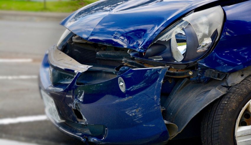 A blue car that has been damaged in a car accident.