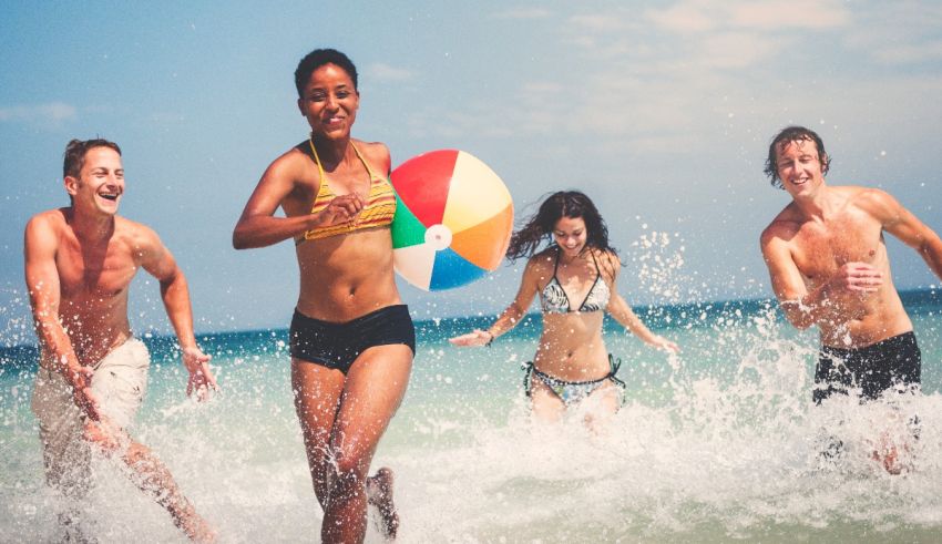 A group of people playing with a beach ball in the ocean.