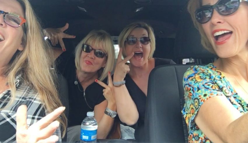 Four women sitting in the back seat of a car.