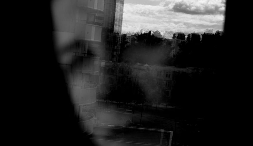 A black and white photo of a building through a window.