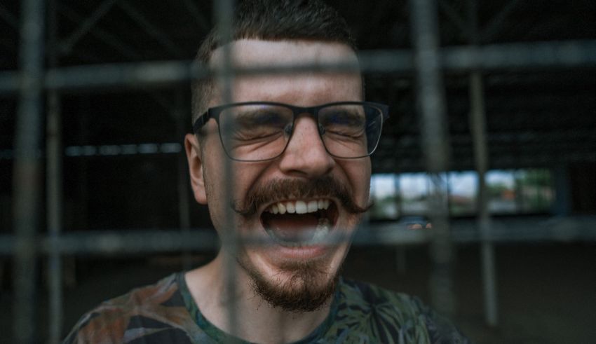 A man laughing behind a cage.
