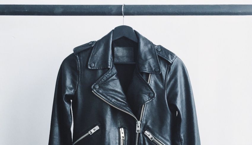 A black leather jacket hanging on a rack.