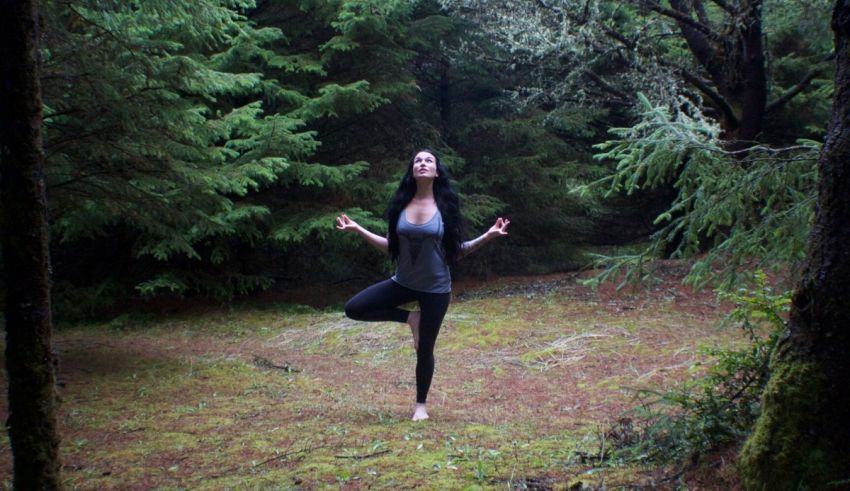 A woman doing yoga in the woods.