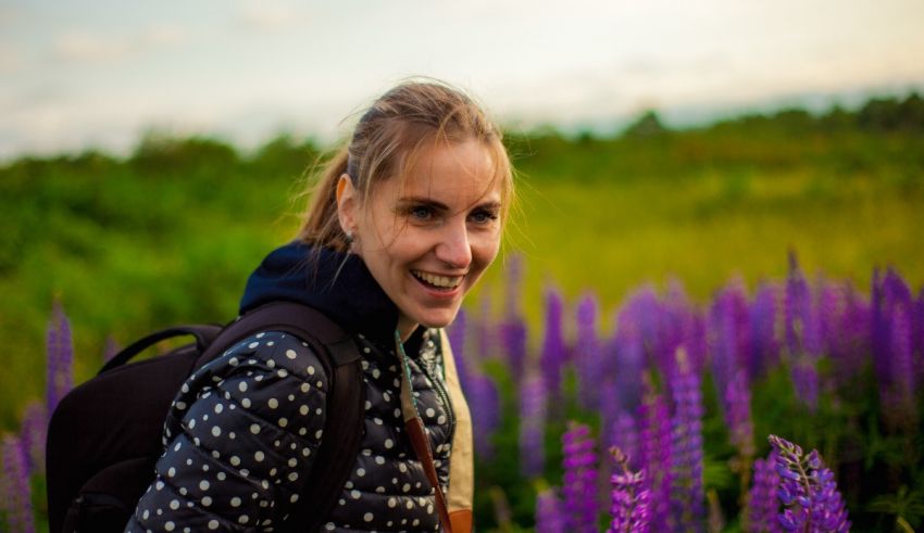 A young woman smiling in a field of purple flowers.