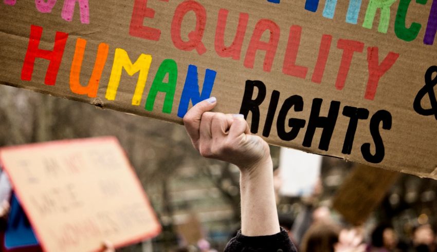A person holding up a sign that says equality and human rights.