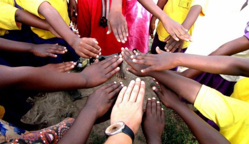 A group of children putting their hands together in a circle.