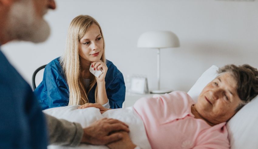 A nurse is talking to an elderly woman in a hospital bed.