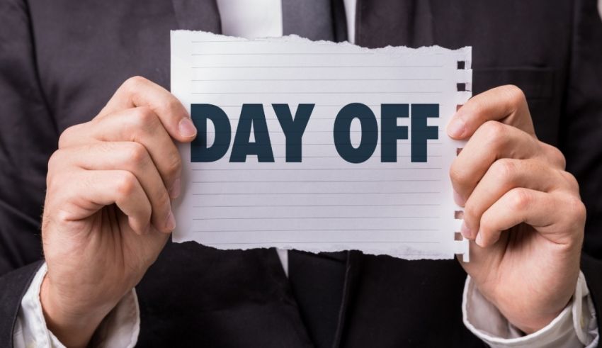 A businessman holding up a piece of paper with the word day off.