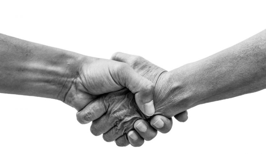 A black and white photo of two people shaking hands.