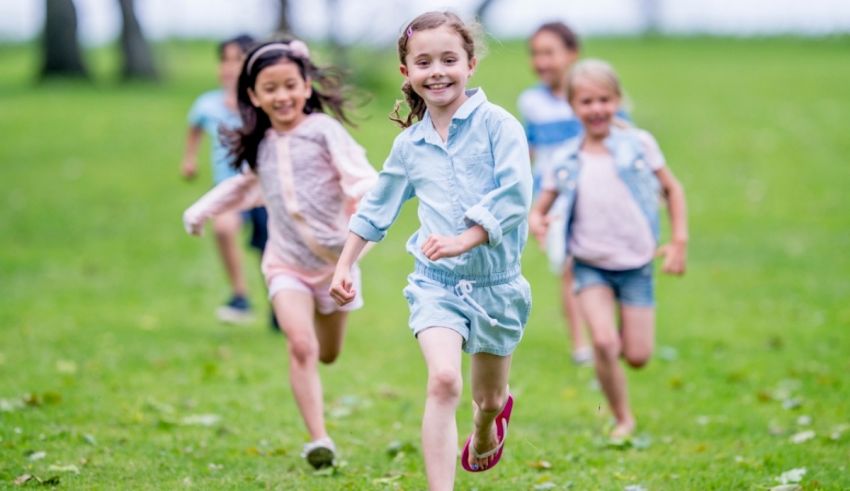 A group of children running on a grassy field.