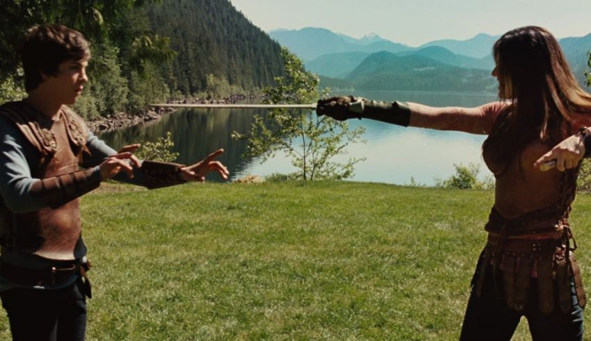 A man and a woman holding swords in a grassy field.