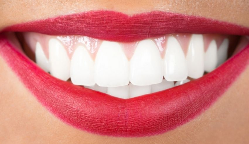 A woman's mouth with white teeth and red lipstick.