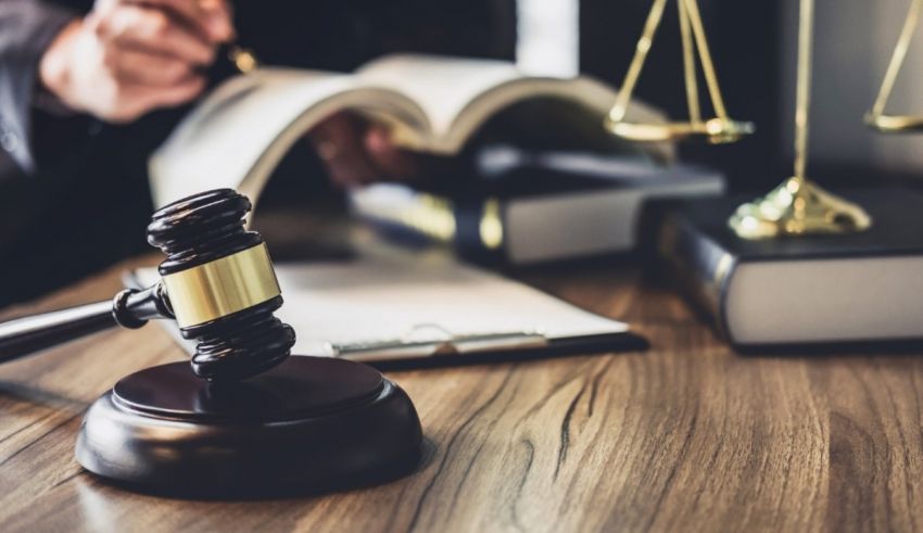 A judge's gavel on top of a book on a desk.