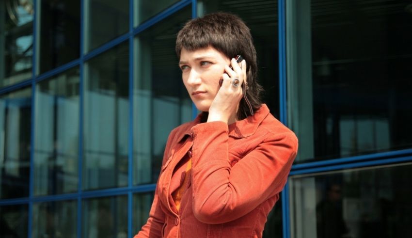 A woman talking on a cell phone in front of a building.