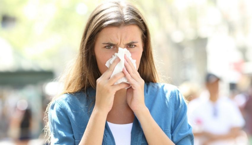 A woman blowing her nose with a tissue.