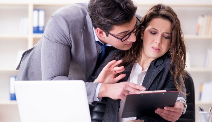 A man and woman are looking at a tablet in an office.