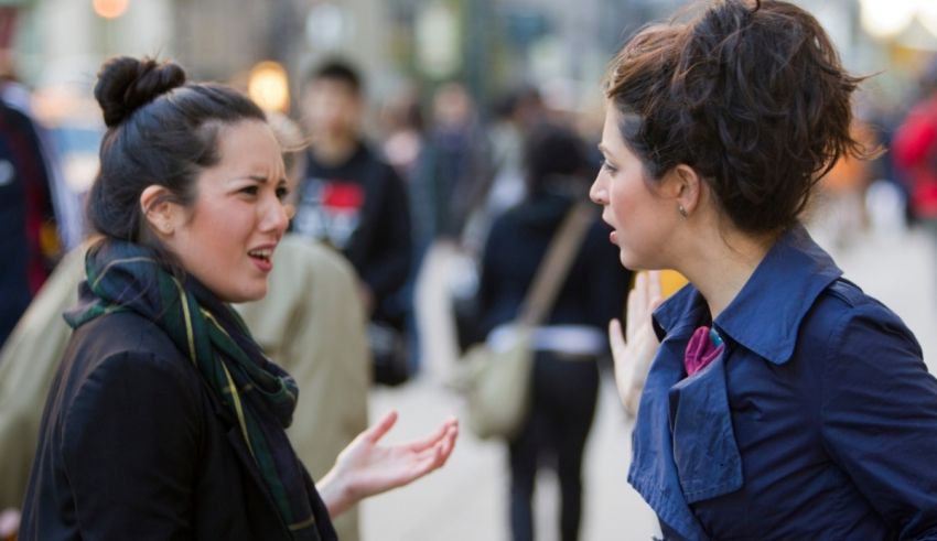 Two women talking to each other on the street.