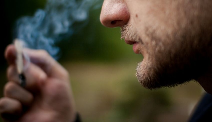 A close up of a man smoking a cigarette.